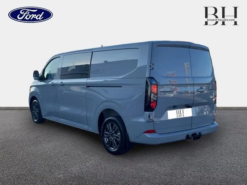 Ford Transit Custom Fourgon gris Matter en vue 3/4 arrière droit avec porte latérale coulissante et attelage remorque visible