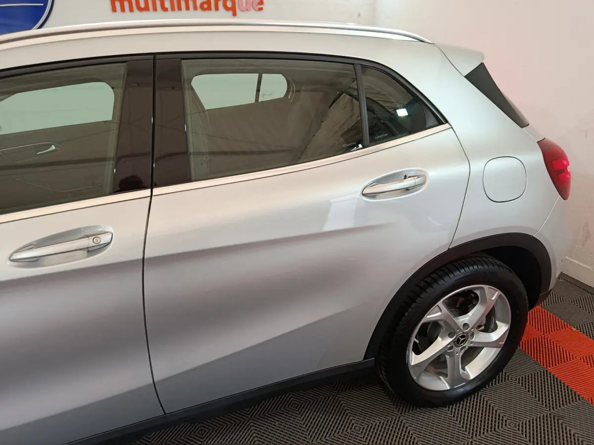 Vue latérale droite d’un Mercedes GLA 200 d Business Executive gris clair, mettant en valeur les jantes alliage et les poignées chromées.