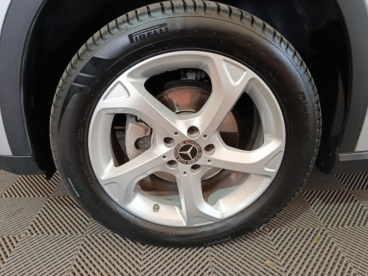 Gros plan sur la roue avant droite d'une Mercedes GLA 200 d gris clair avec jante alliage cinq branches et pneu Pirelli.