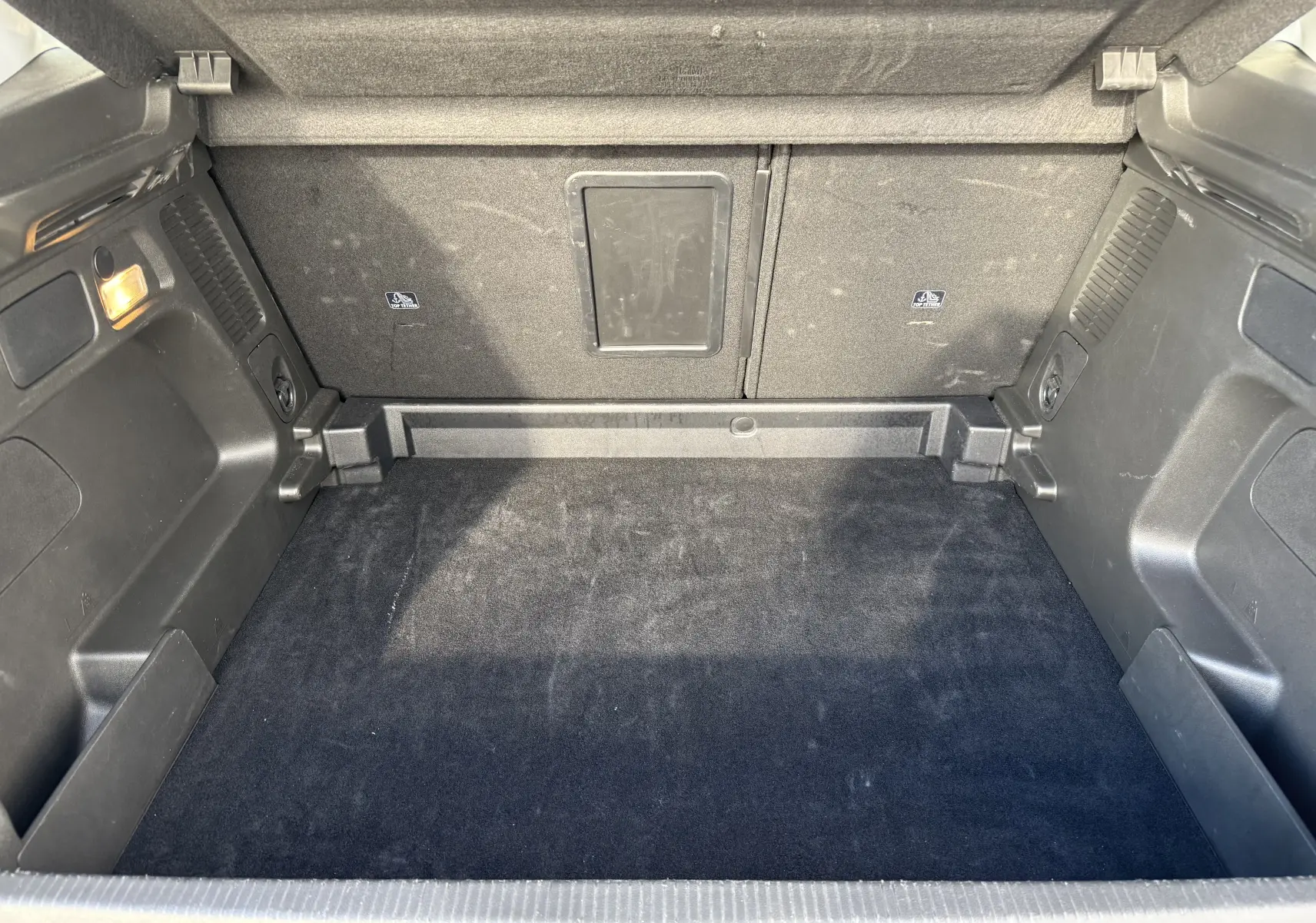 Coffre spacieux et propre de l'Opel Grandland 2024 gris Artense avec toit noir, vue intérieure arrière.