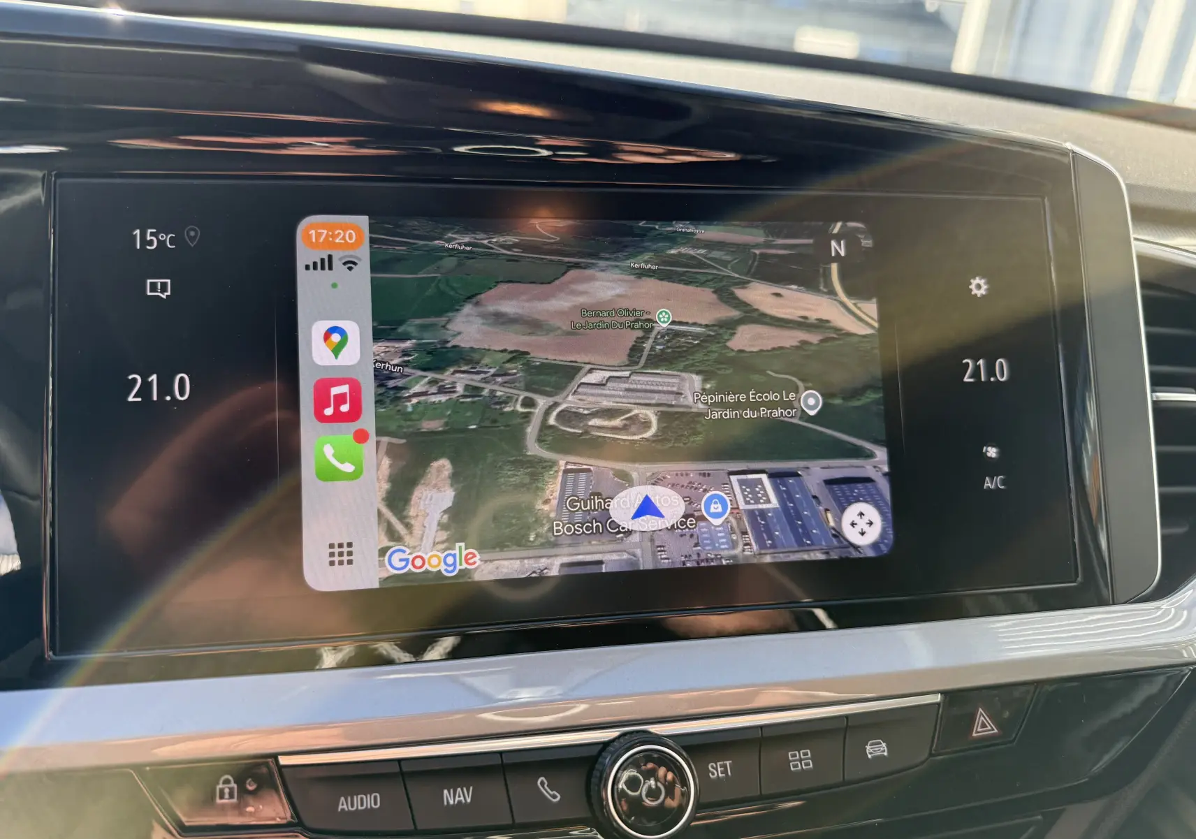 Écran tactile central de l'Opel Grandland 2024 affichant la navigation avec carte satellite et commandes climatisation à 21°C.
