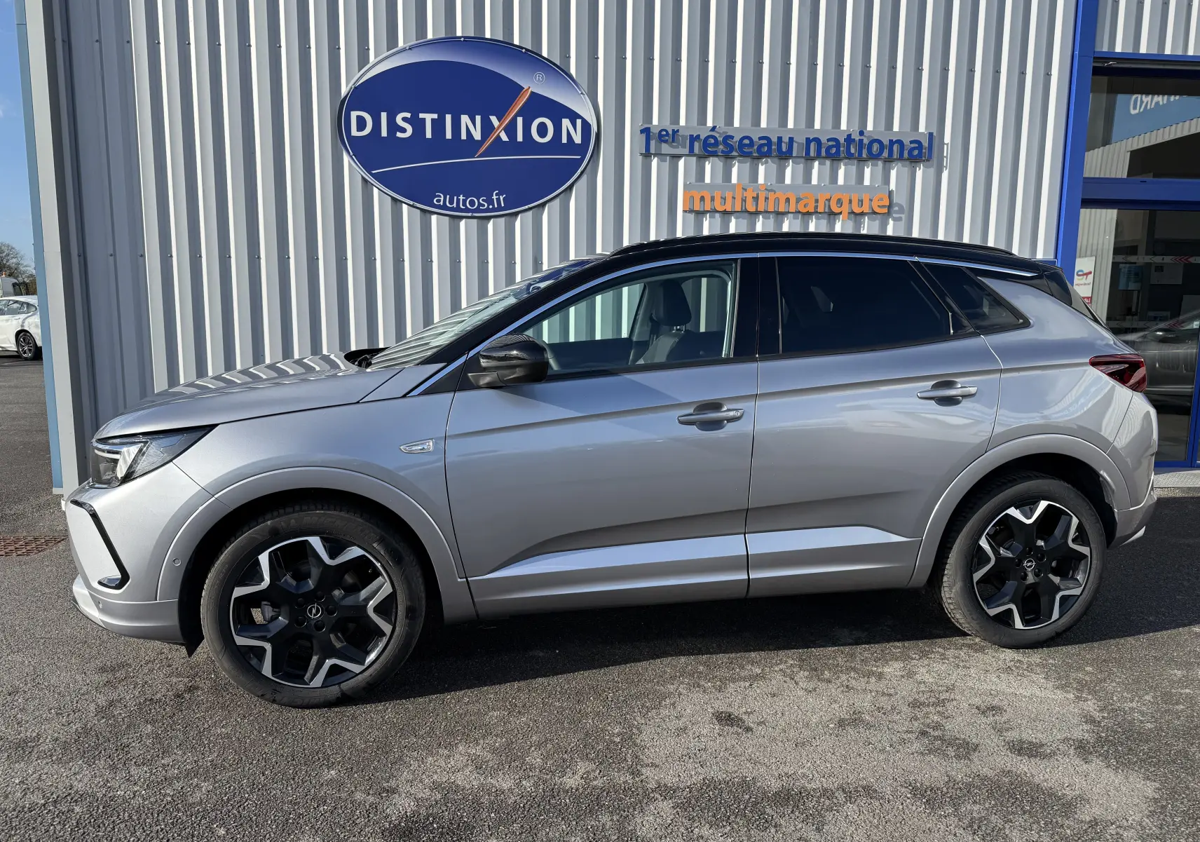 Opel Grandland gris Artense avec toit noir Perla Nera, vue de profil côté gauche, roues alliage noires.