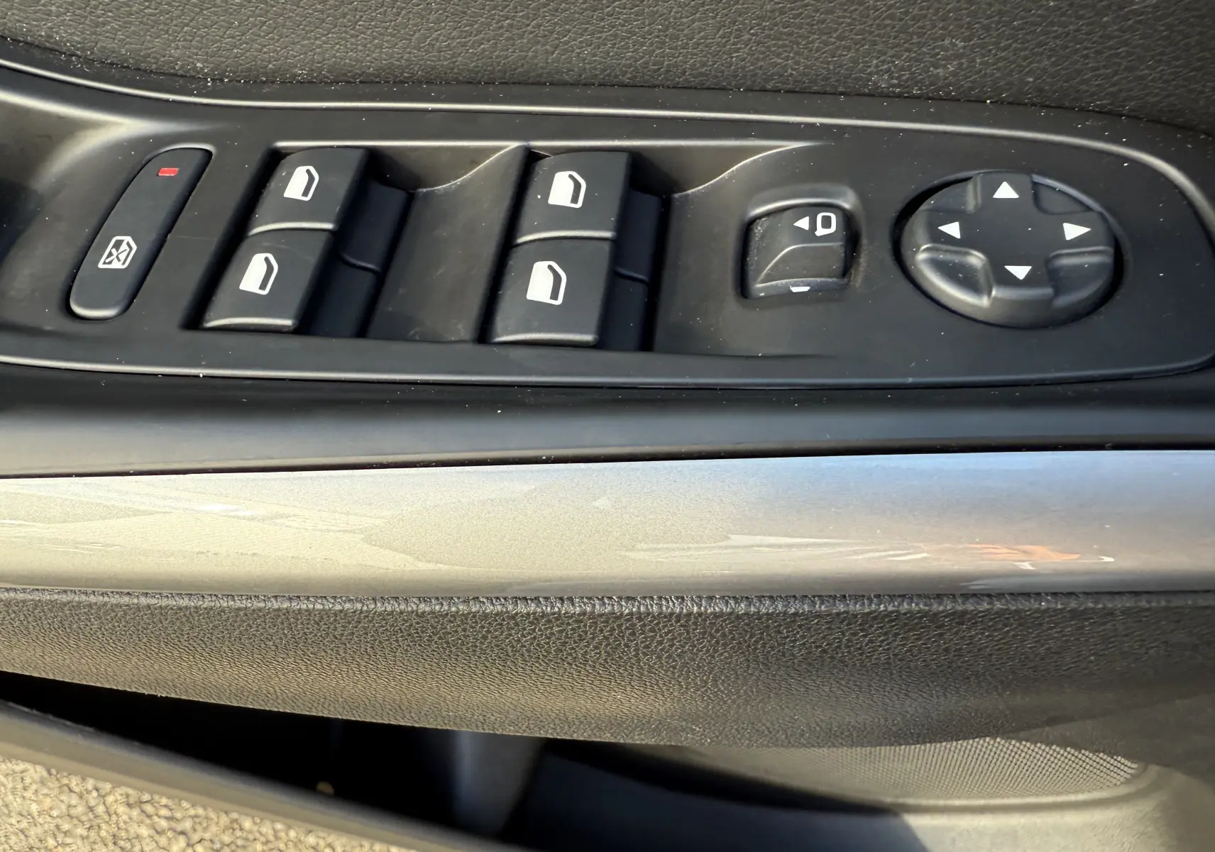 Gros plan sur les commandes de lève-vitres et réglage des rétroviseurs côté conducteur de l'Opel Grandland gris Artense toit noir.