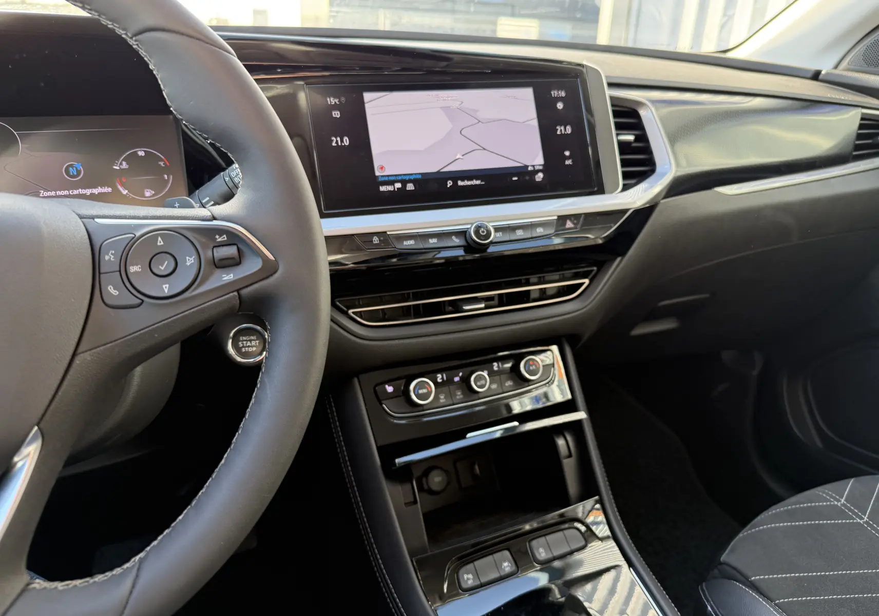 Intérieur de l'Opel Grandland 2024, vue du poste de conduite avec écran tactile et volant en cuir noir.