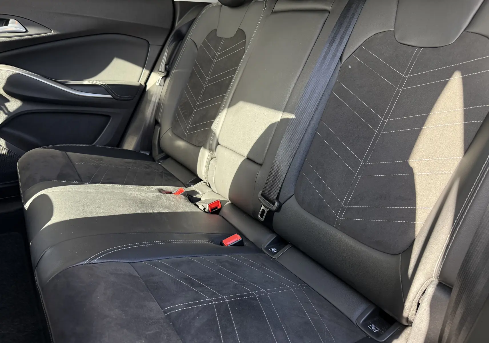 Vue latérale droite des sièges arrière en cuir noir avec surpiqûres blanches de l'Opel Grandland 2024 finition Ultimate.