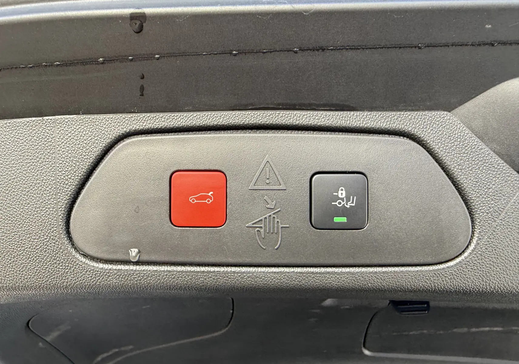 Gros plan sur les boutons d'ouverture et de verrouillage du hayon du coffre de l'Opel Grandland gris artense toit noir.