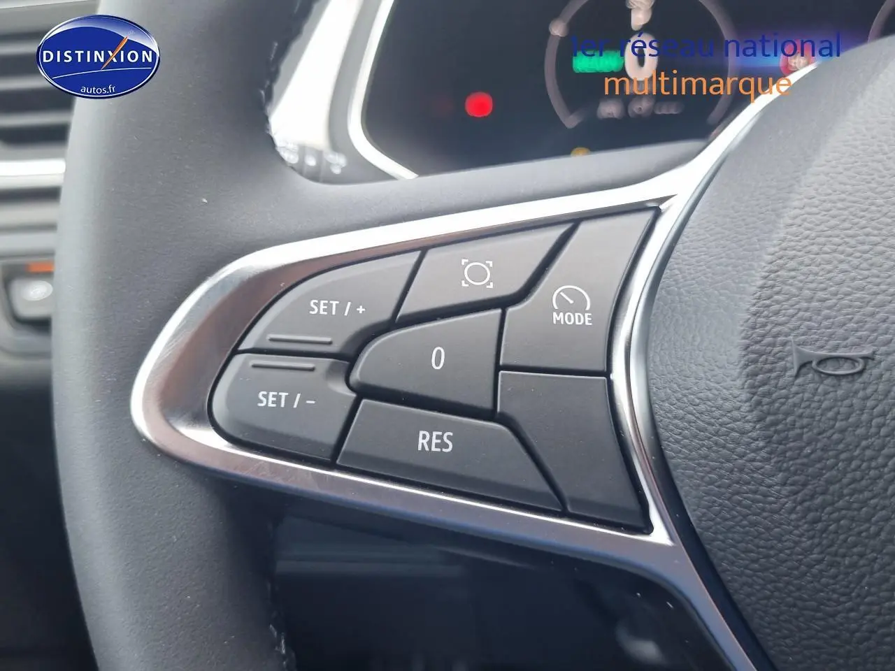 Gros plan sur les commandes multifonctions du volant du Renault Captur gris rafale 2025 hybride.