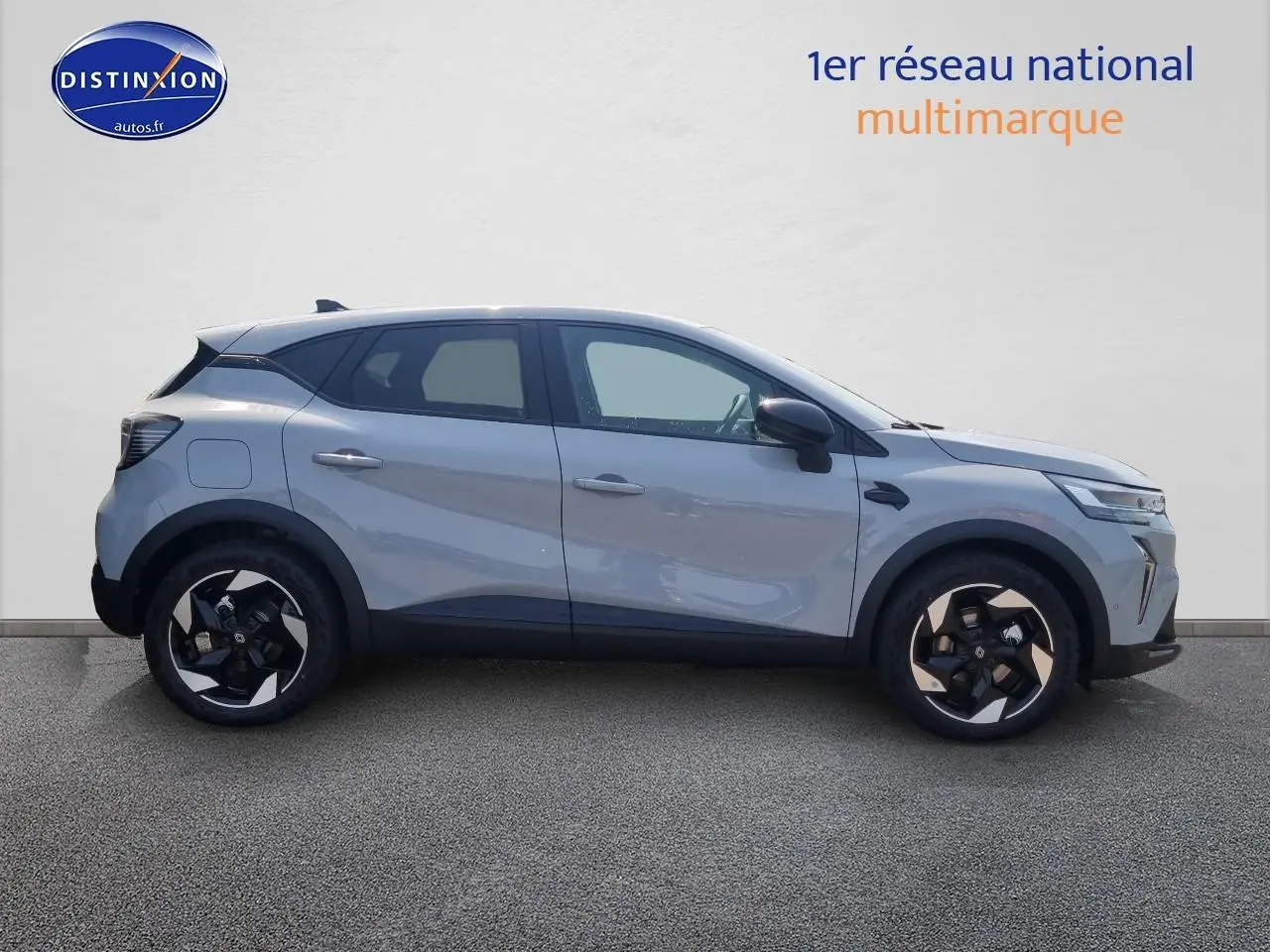 Profil droit d'un Renault Captur gris rafale 2025 avec jantes alliage au design moderne et toit noir contrasté.