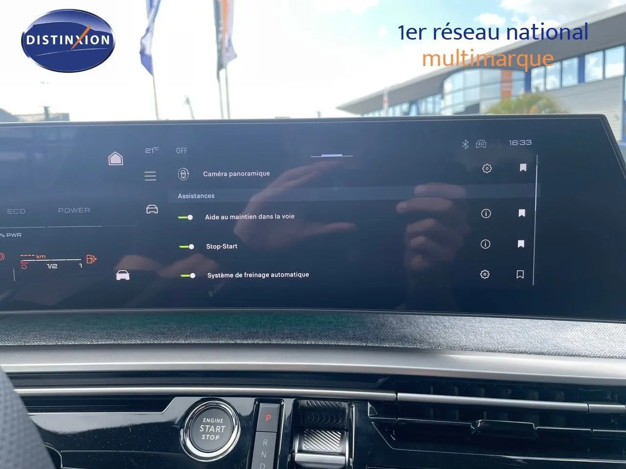 Tableau de bord du Peugeot 5008 Hybrid 2025 avec écran tactile affichant les aides à la conduite, intérieur moderne noir.