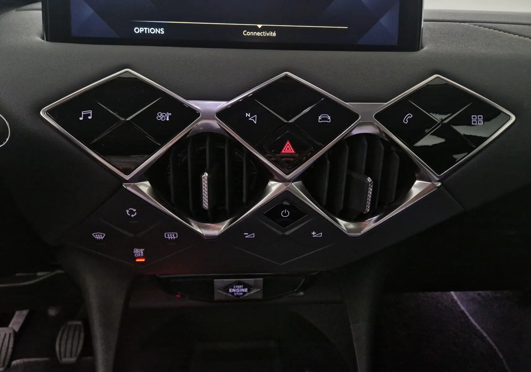 Vue rapprochée du tableau de bord du DS3 Crossback 2022, mettant en valeur les commandes tactiles noires et les aérateurs chromés.