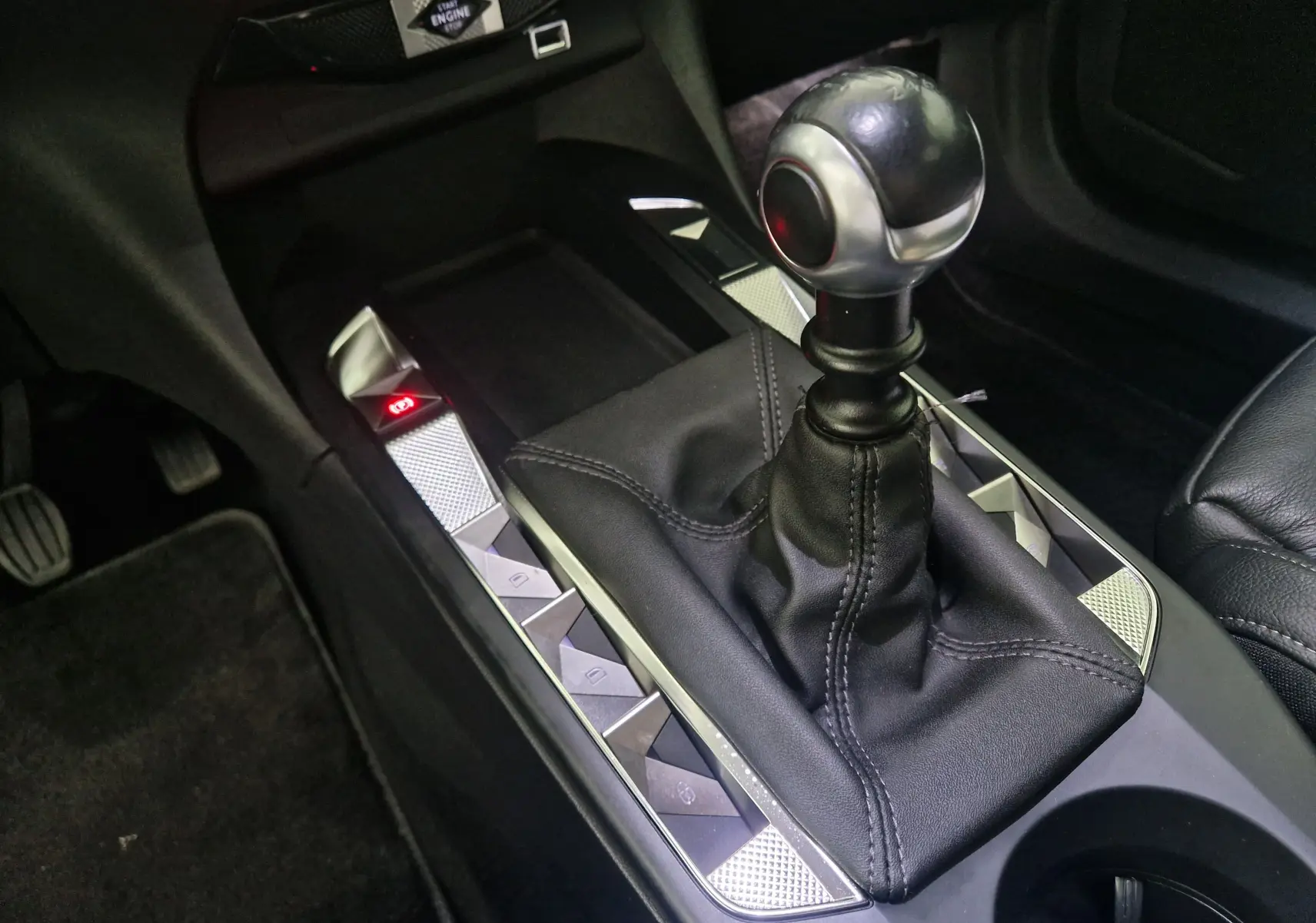 Le levier de vitesses manuel en cuir noir du DS3 Crossback 2022, avec boutons de commande argentés autour.