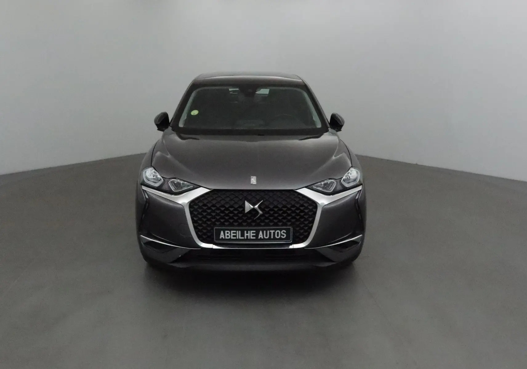 Vue frontale d'un DS3 Crossback gris platinium avec calandre noire et logo DS bien visible.