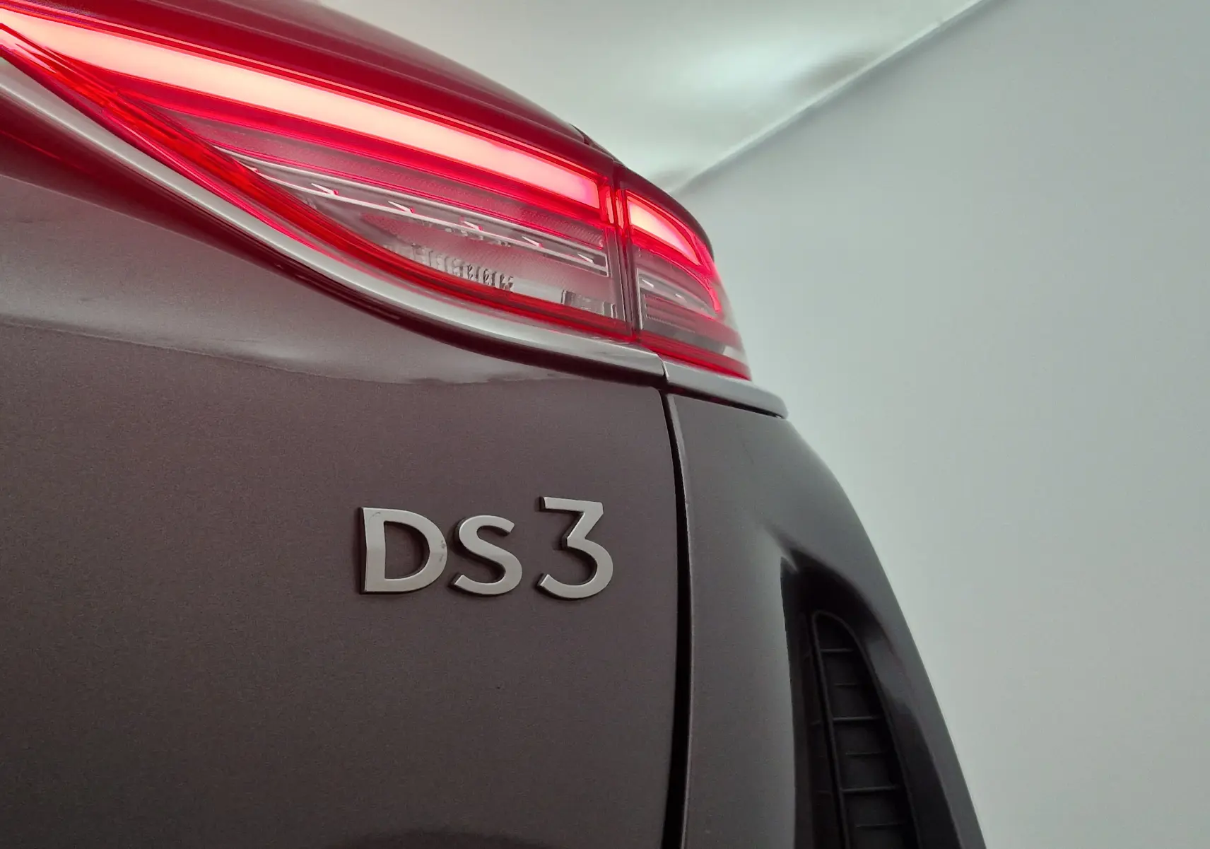 Gros plan sur le feu arrière droit rouge et l'inscription DS3 d'un DS3 Crossback gris platinium.