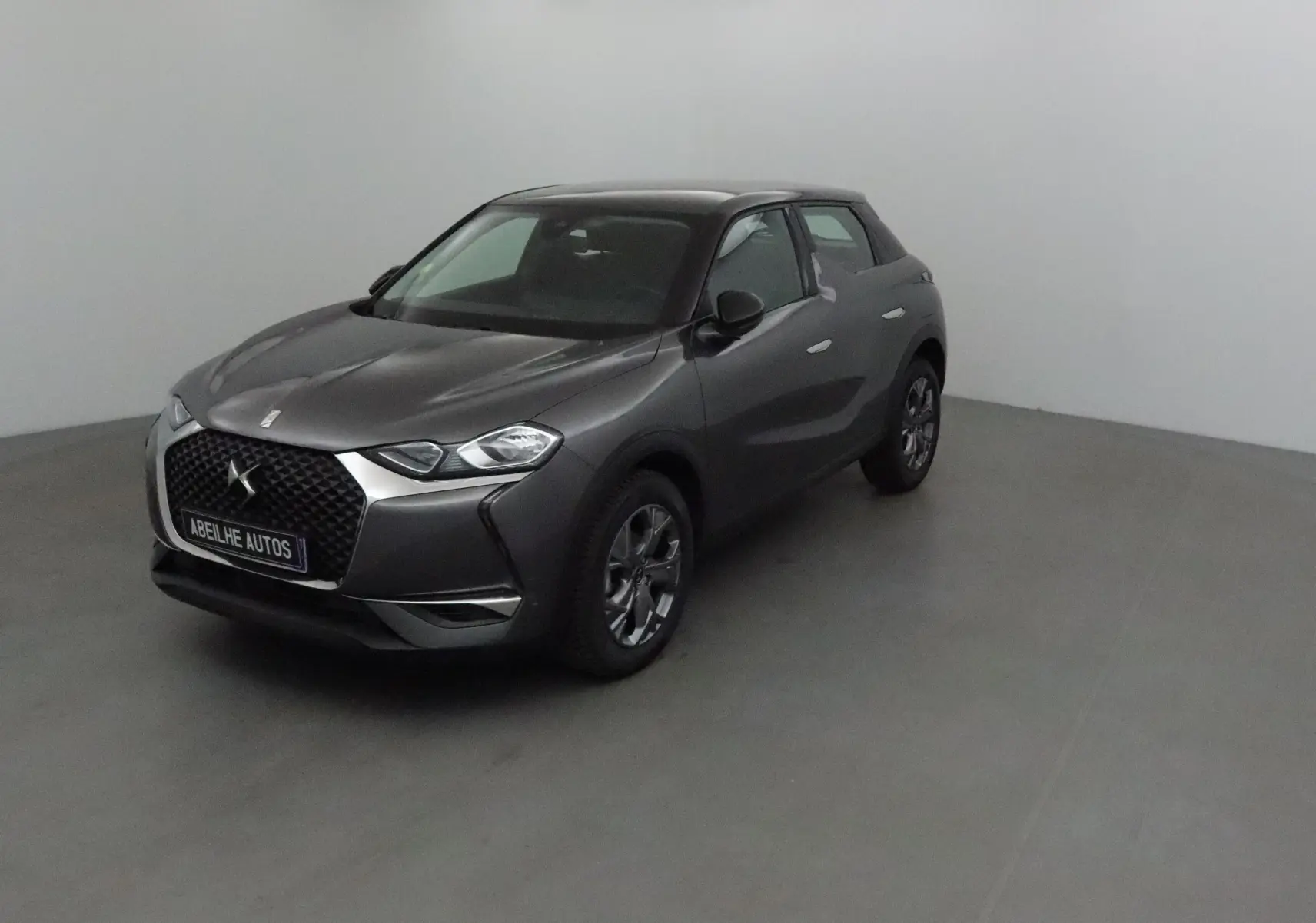 DS3 Crossback gris platinium vue 3/4 avant droit, mettant en valeur sa calandre distinctive et ses jantes alliage.
