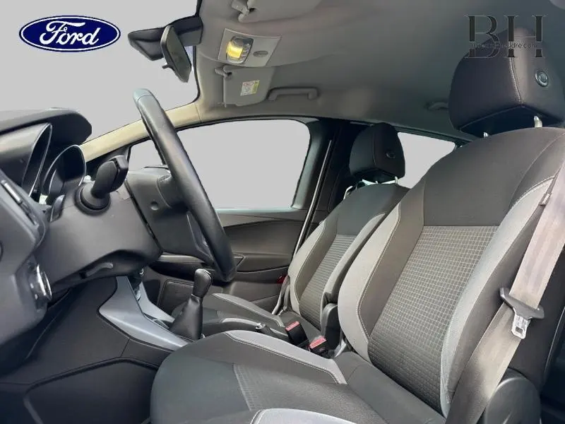 Intérieur avant du Ford B-MAX blanc Glacier 2017, sièges tissu gris avec volant cuir et levier manuel visible.