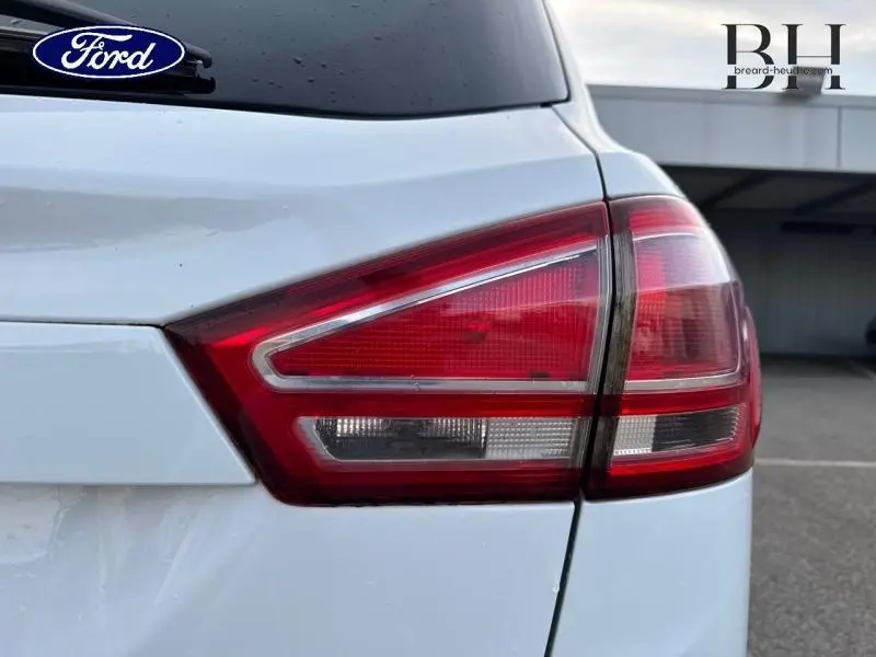 Gros plan sur le feu arrière droit d'une Ford B-MAX 1.4 90ch Edition blanc glacier, avec carrosserie et lunette arrière visibles.