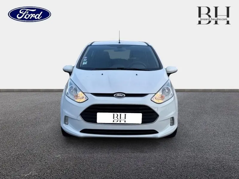 Vue frontale d'une Ford B-MAX 1.4 90ch Edition blanche Glacier avec phares allumés sur fond neutre.