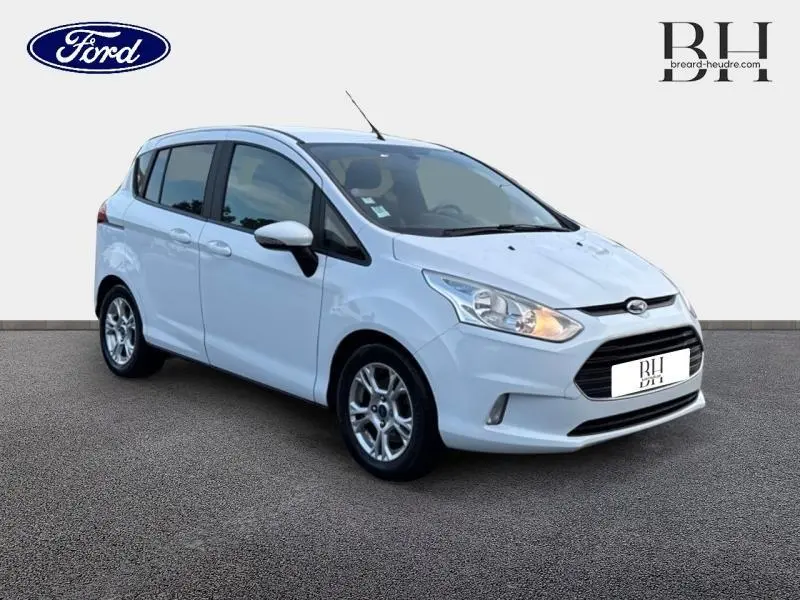 Vue 3/4 avant droite d'une Ford B-MAX blanche Glacier avec jantes alliage et feux allumés.