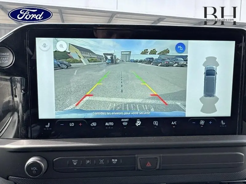 Écran tactile intérieur montrant la caméra de recul du Ford Transit Custom bleu azur, avec vue arrière et aides au stationnement.