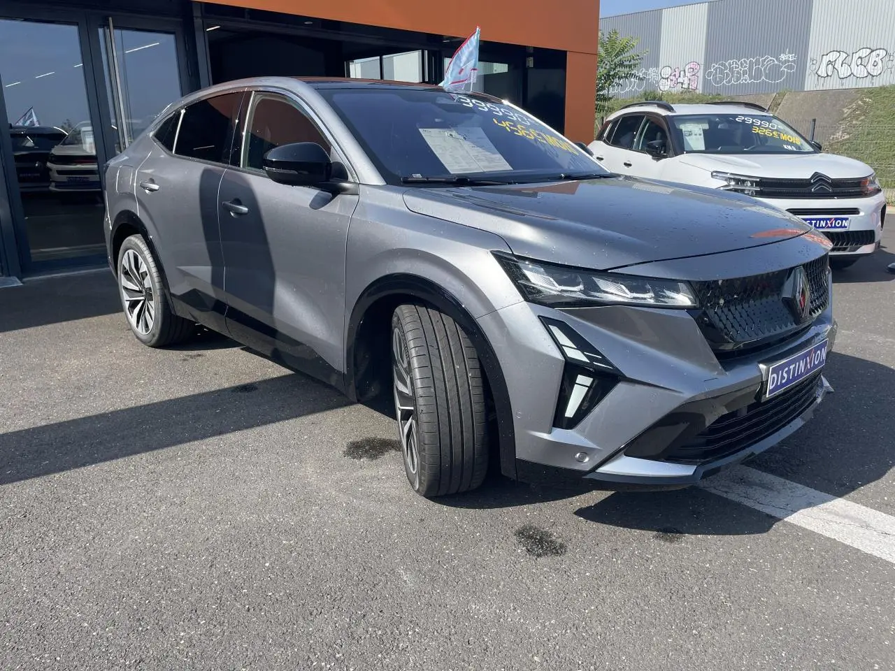 Renault Rafale gris avec toit noir, vue 3/4 avant droit, calandre noire et jantes alliage 20 pouces.