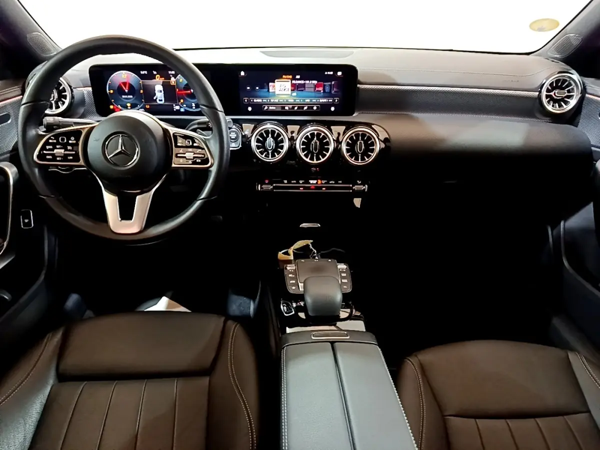 Vue intérieure avant de la Mercedes Classe A A 200 d Progressive Line 2022, tableau de bord noir avec écran tactile et volant cuir.
