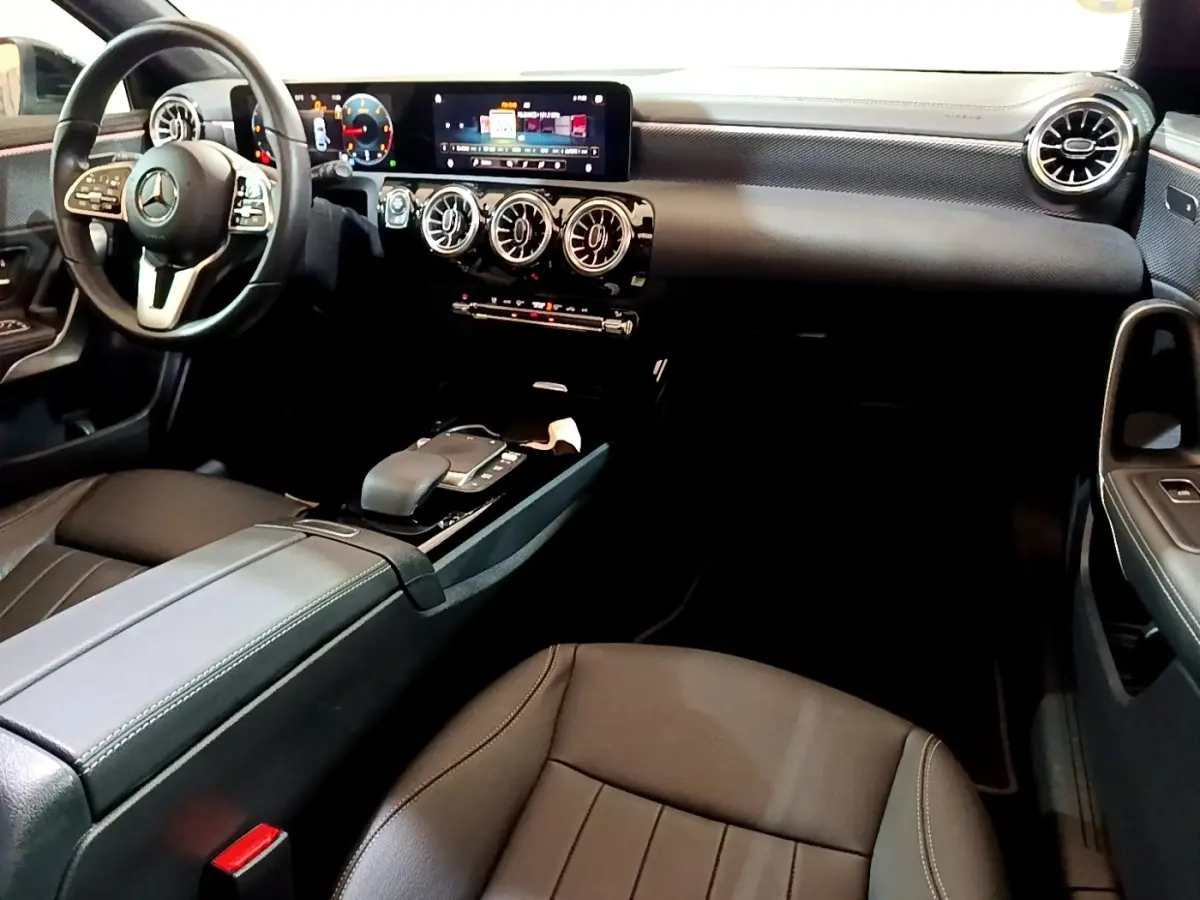Intérieur noir de la Mercedes Classe A 200 d 2022, vue côté conducteur montrant volant cuir et tableau de bord digital.