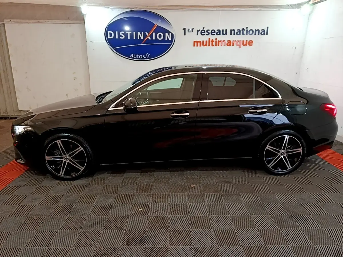 Profil droit d'une Mercedes Classe A Berline noire 2022, avec jantes alliage et feux arrière allumés en intérieur.