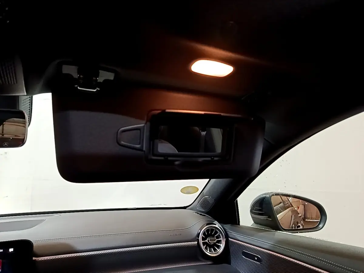 Intérieur de la Mercedes Classe A 200 d Progressive Line 2022, vue côté passager avec pare-soleil ouvert et éclairage intérieur allumé.