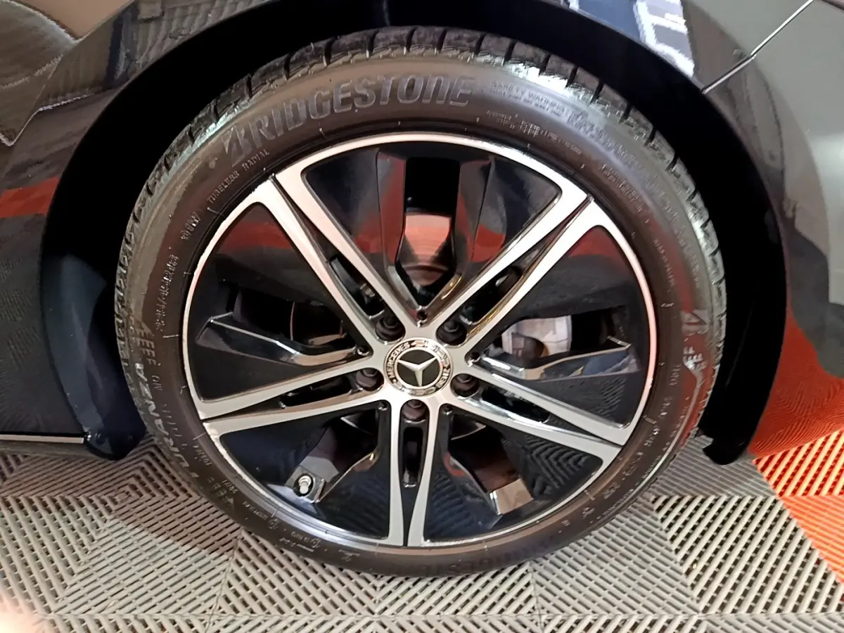 Gros plan sur la roue avant droite noire d'une Mercedes Classe A 200 d Progressive Line 2022 avec jante alliage bicolore.