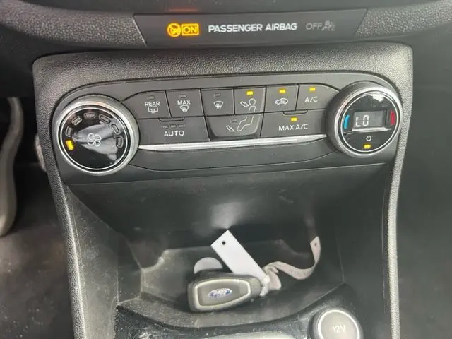 Vue rapprochée de la console centrale de la Ford Fiesta 2018 gris, montrant les commandes de climatisation et la clé dans le rangement.