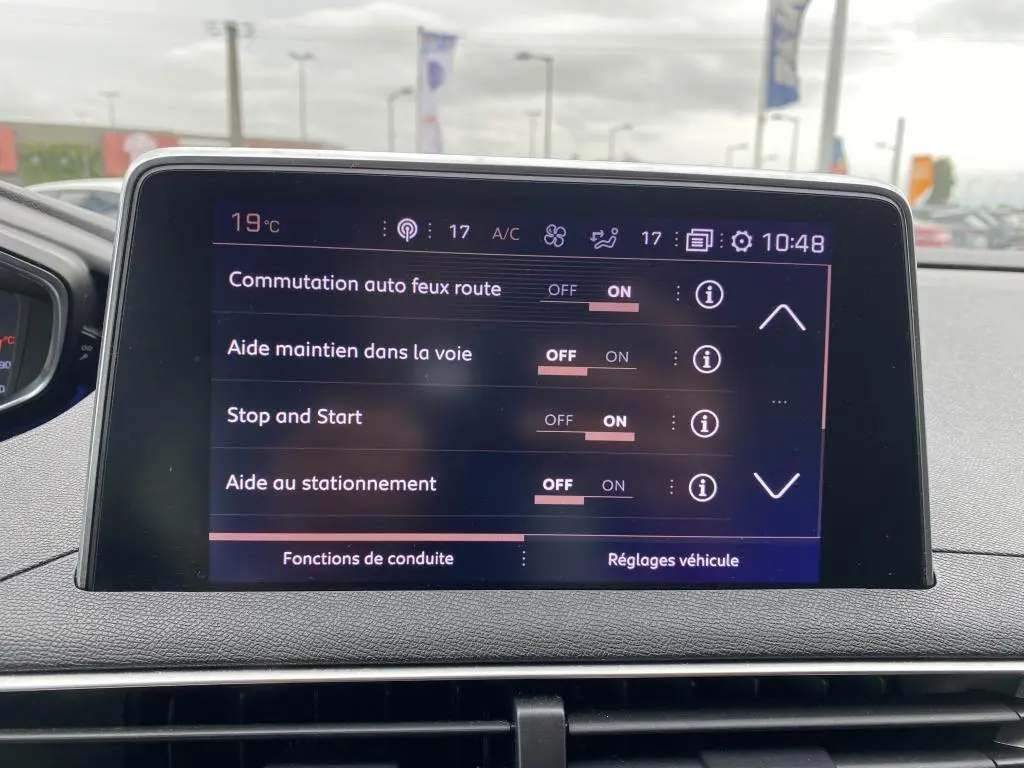 Écran tactile du Peugeot 3008 GT Line blanc montrant les réglages d'aides à la conduite et climatisation.
