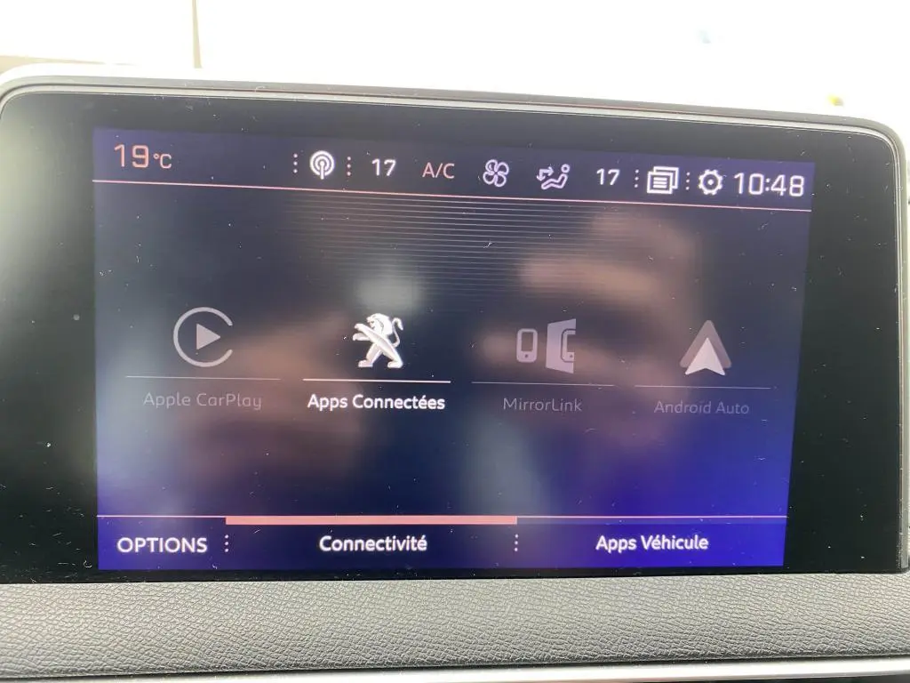 Écran tactile central du Peugeot 3008 blanc 2018 affichant les options de connectivité et applications embarquées.