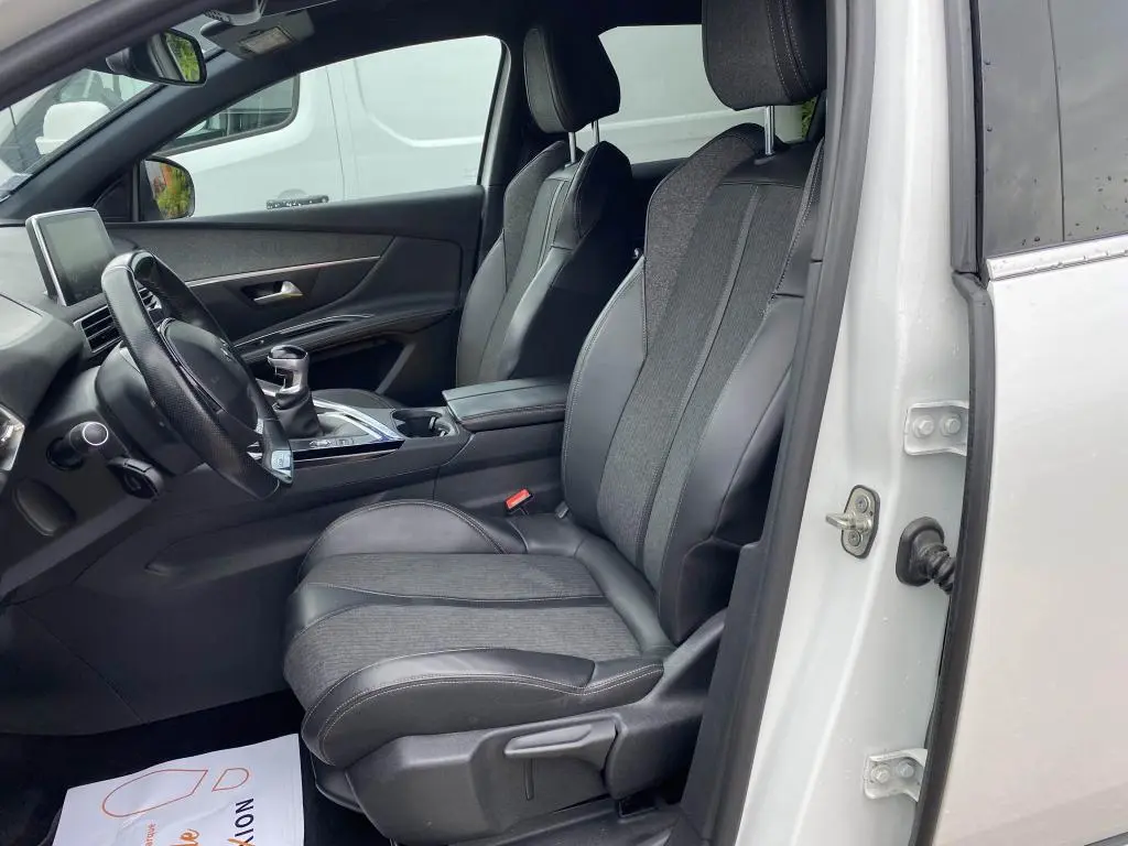 Vue intérieure côté conducteur du Peugeot 3008 blanc nacré 2018, sièges TEP et tissu gris avec volant compact.