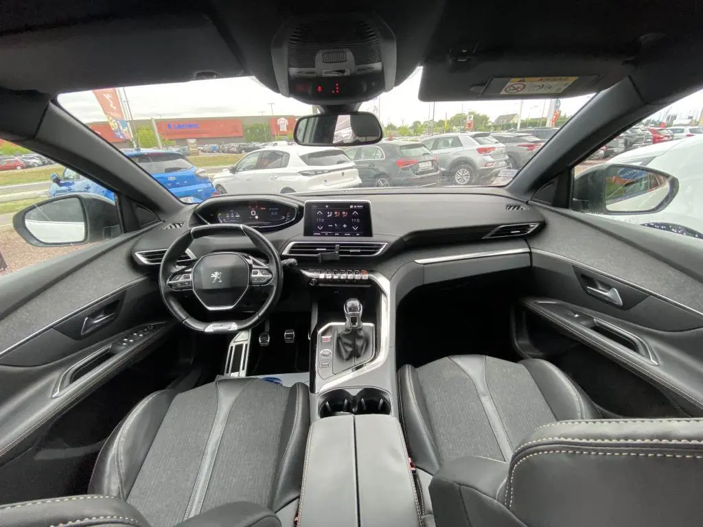 Vue intérieure avant du Peugeot 3008 blanc 2018, volant compact, écran tactile 8 pouces et sellerie noire TEP & tissu.