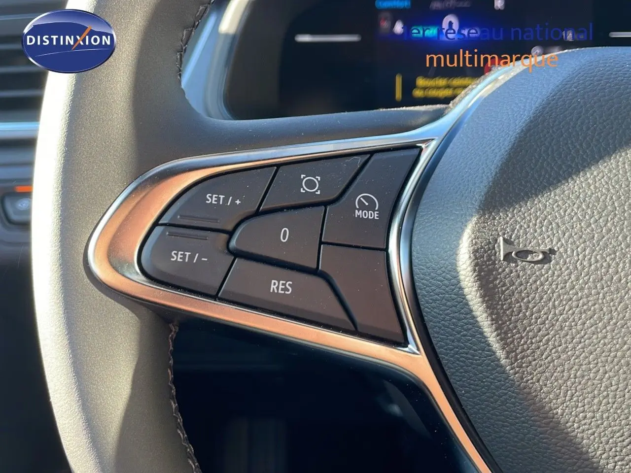 Gros plan sur les commandes au volant du Renault Captur E-Tech gris rafale, soulignant les boutons de régulateur de vitesse.