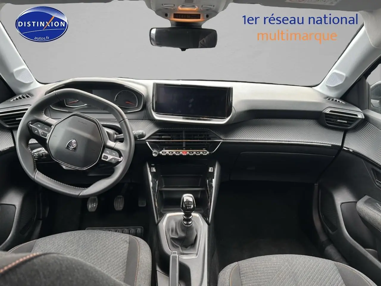 Vue intérieure avant de la Peugeot 208 1.2 100 style 2025, volant compact et tableau de bord moderne avec écran tactile.