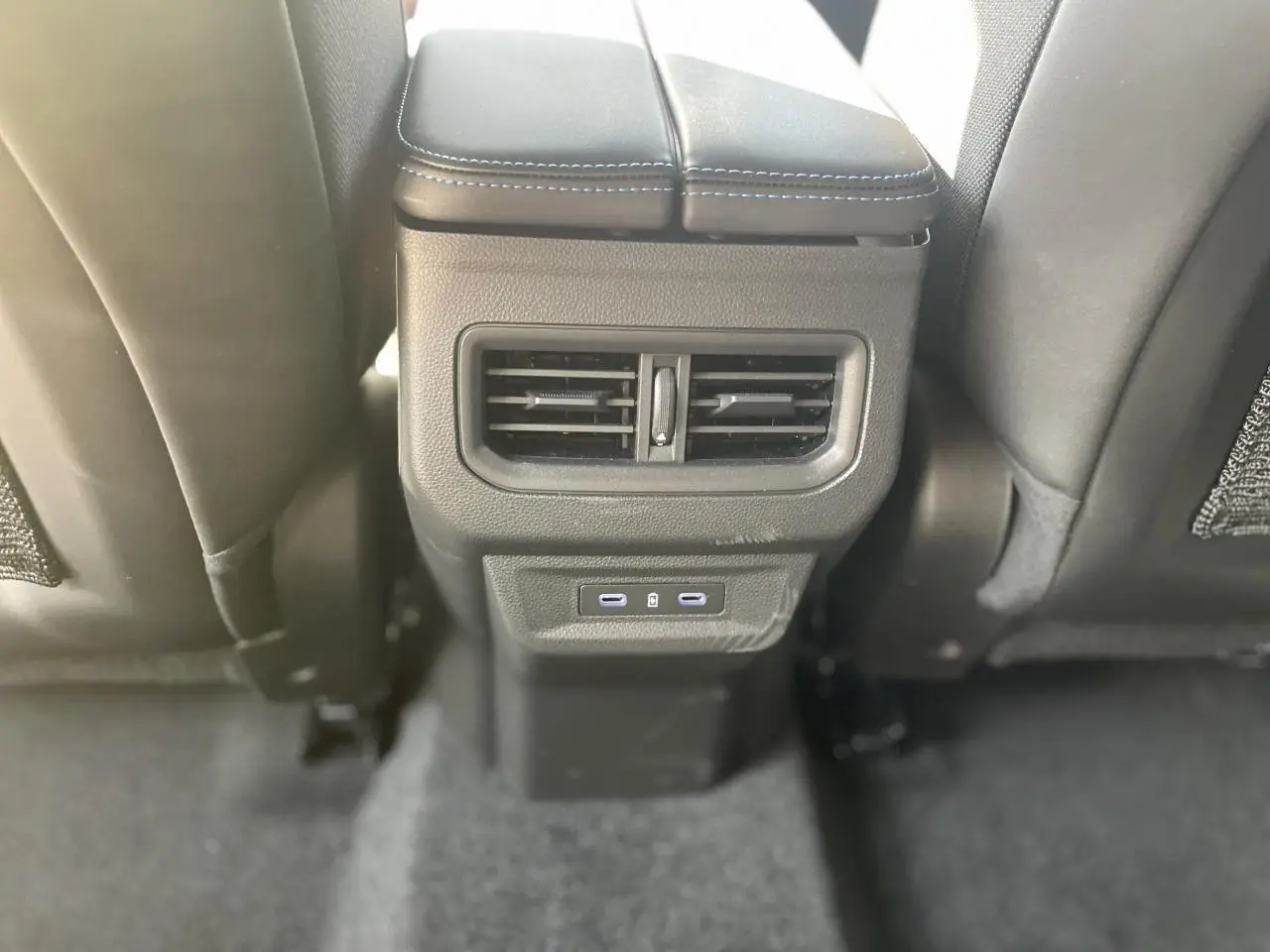 Vue rapprochée de la console arrière noire avec sorties d’air et deux ports USB-C du Renault Rafale Esprit Alpine 2025.