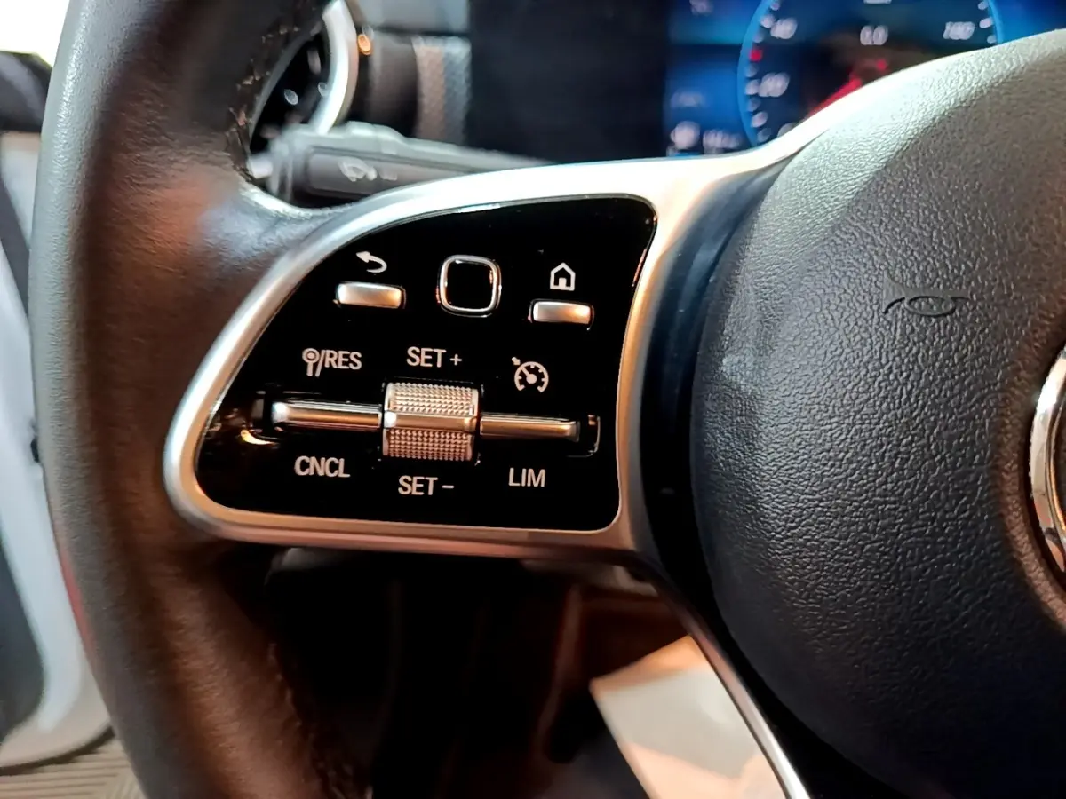 Gros plan sur la partie gauche du volant cuir noir de la Mercedes CLA 200 d Business Line 2021 avec commandes multifonctions.