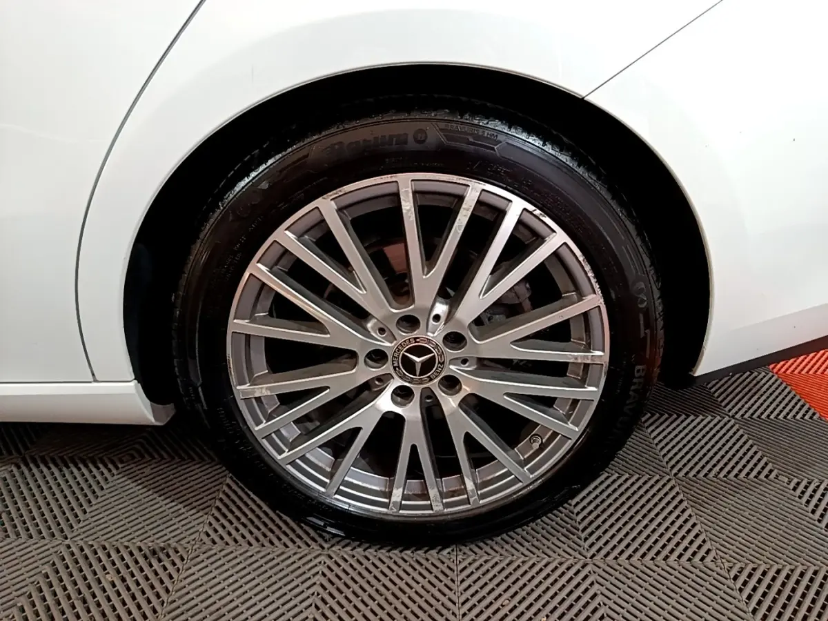 Gros plan sur la roue arrière droite d’une Mercedes CLA 200 d Business Line blanche, jante alliage multi-branches.