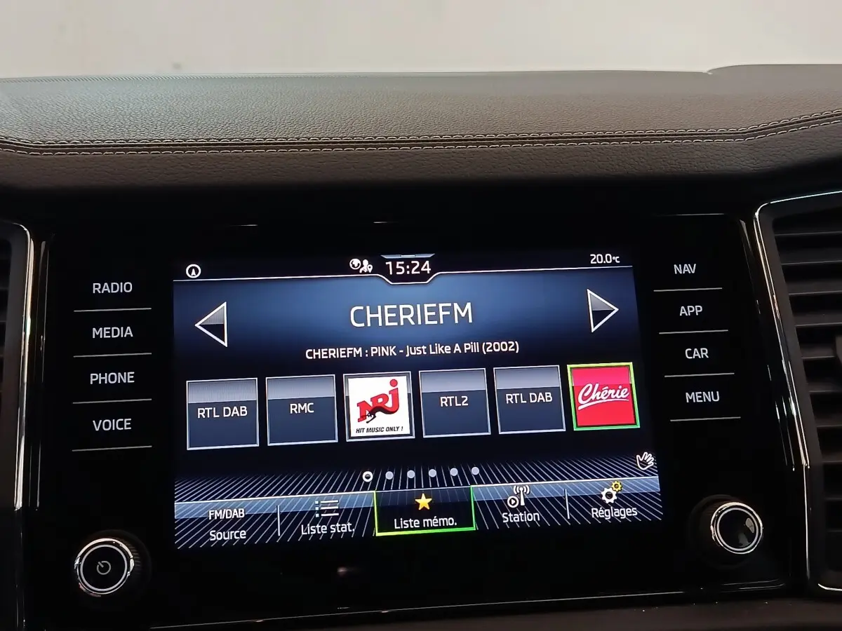 Écran tactile central du Skoda Kodiaq blanc, affichant la radio avec options médias et navigation visibles.