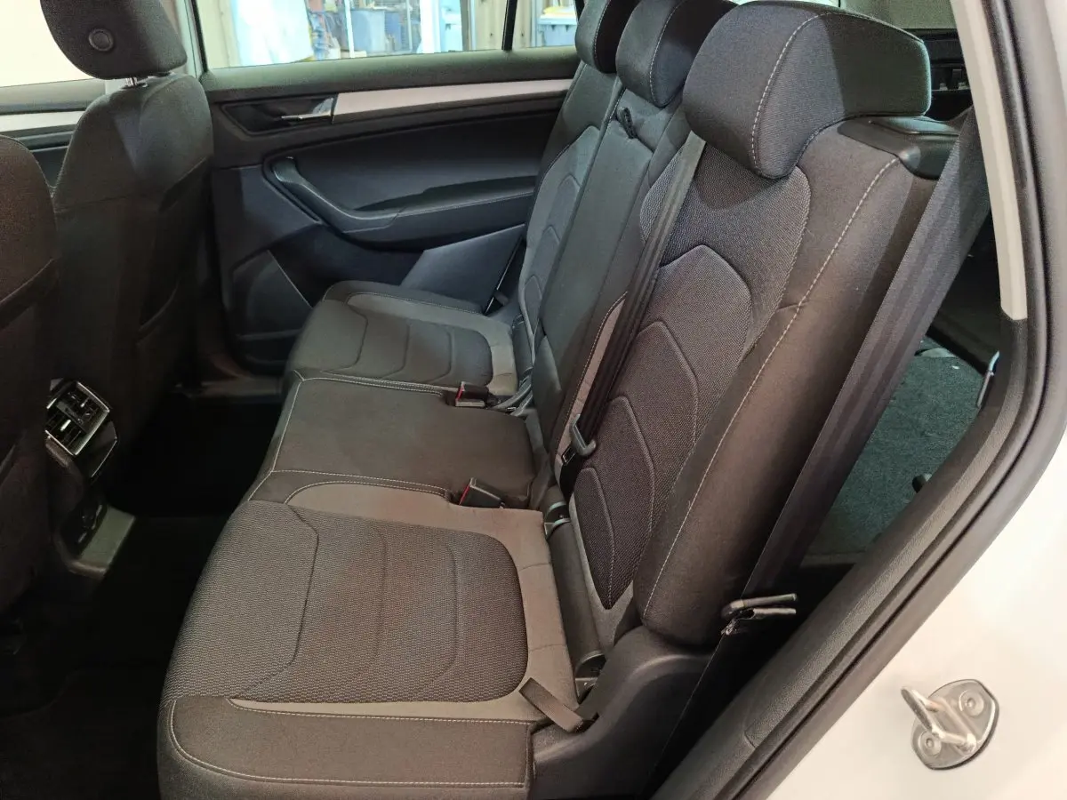 Vue côté droit de la banquette arrière noire du Skoda Kodiaq blanc 2022 avec ceinture et appuie-têtes visibles.