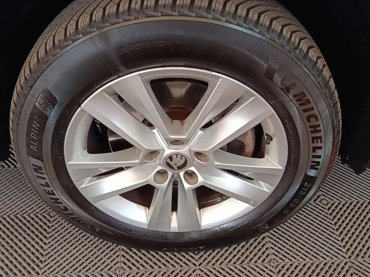 Gros plan sur la roue avant droite d’un Skoda Kodiaq blanc avec jante alliage et pneu Michelin Alpin 7.