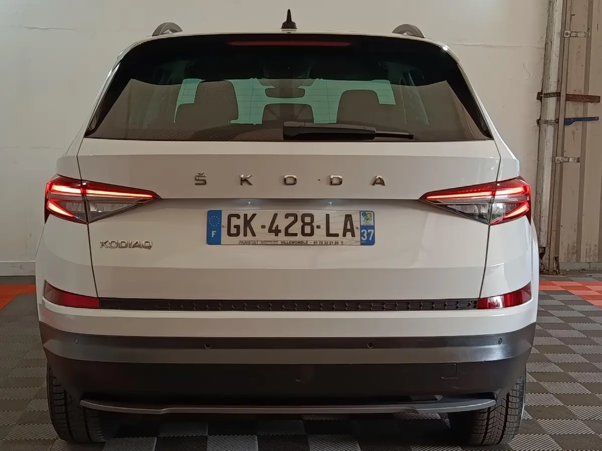 Vue arrière d’un Skoda Kodiaq blanc 2022 avec feux LED allumés et plaque d’immatriculation française visible.