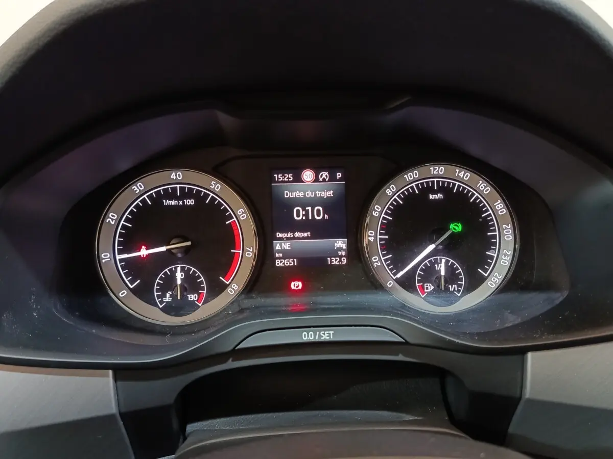 Vue rapprochée du tableau de bord digital du Skoda Kodiaq blanc, affichant compte-tours et vitesse.