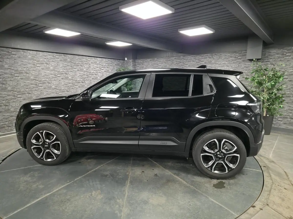 Vue de profil côté gauche du Jeep Avenger noir 2025 avec jantes alliage et vitres arrière surteintées.