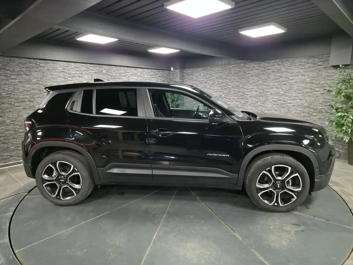 Jeep Avenger noir vu de profil côté gauche, avec jantes alliage distinctives et finition noire brillante.
