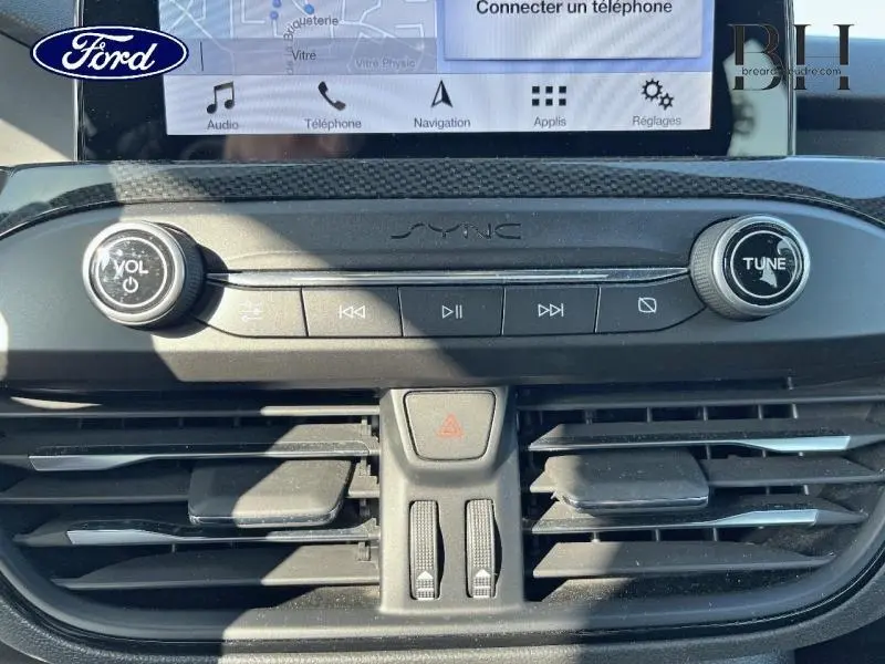 Gros plan sur la console centrale du Ford Focus gris lunaire 2019, mettant en valeur le système audio SYNC 3 et les commandes de ventilation.