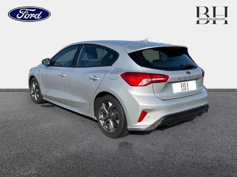 Vue 3/4 arrière droite d'une Ford Focus gris lunaire 2019 avec jantes alu et feux arrière LED distinctifs.
