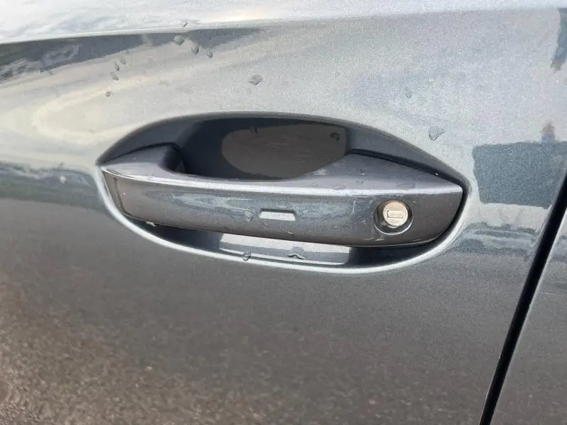 Poignée de porte gris magnétique métallisé de la CUPRA Formentor 2024 avec serrure intégrée visible en gros plan côté droit.