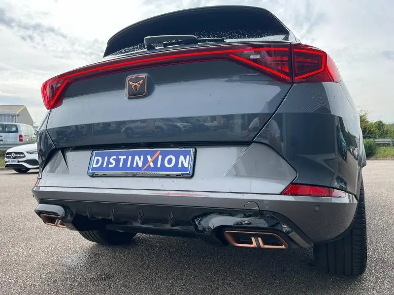 Vue arrière basse d'une CUPRA Formentor gris magnétique avec double sortie d'échappement Copper stylisée et feux LED.
